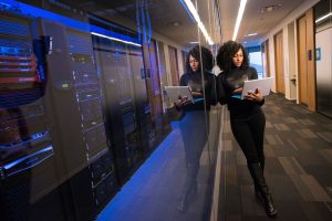 menina mexendo no notebook dentro do data center