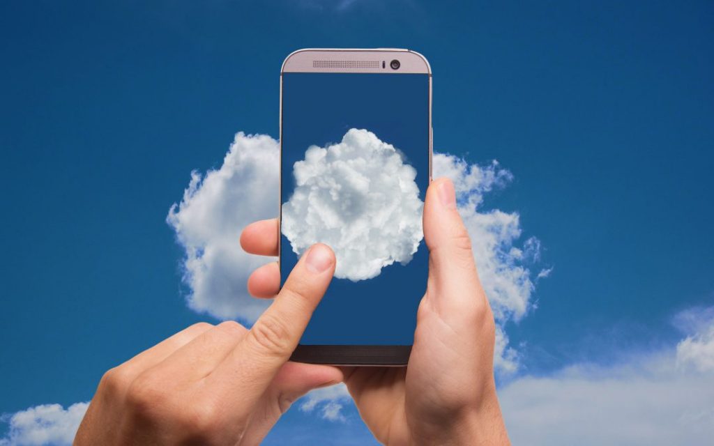 Pessoa segurando o celular com nuvem na tela