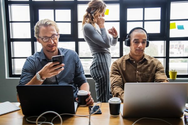 Pessoas mexendo no celular no trabalho